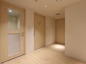 A hallway with wooden doors, one labeled 'Smoking Room.' - Henn na Hotel Premier Nagoya Fushimi Ekimae (Nagoya)