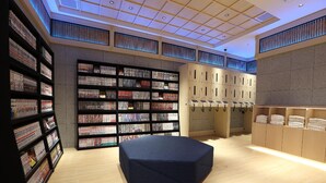 Una biblioteca moderna con estanterías, un área de descanso y taquillas.