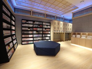 A modern library with bookshelves, a seating area, and lockers. - Henn Na Hotel Express Nagoya Fushimi Ekimae (Nagoya)
