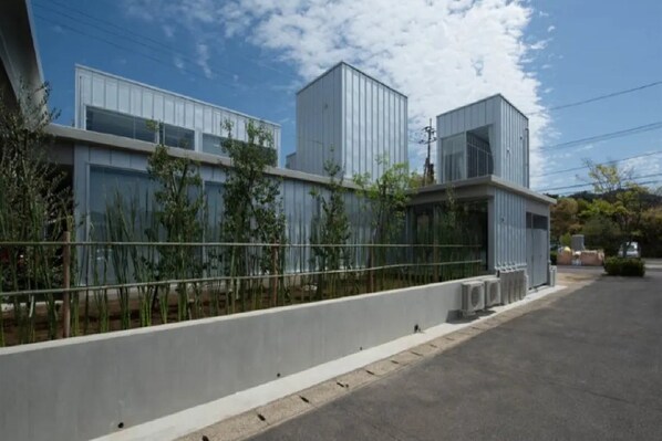 A modern building with a flat roof, large windows, and a metal facade. - Arita Huis (Arita)
