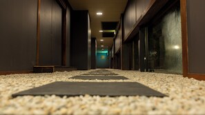 A corridor with a carpeted floor, wooden walls, and a bench. - Tamana Onsen Nakoikan Villa Tamayura (Tamana)