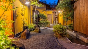 A traditional Japanese-style garden with a gravel path, wooden structures, and well-maintained greenery. - Tamana Onsen Nakoikan Villa Tamayura (Tamana)