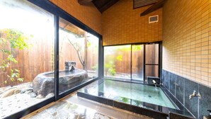 A traditional Japanese onsen with a stone bath, wooden walls, and a view of a garden. - Tamana Onsen Nakoikan Villa Tamayura (Tamana)