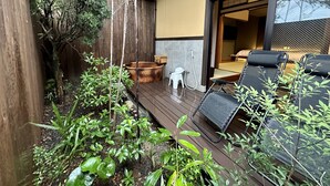 A wooden deck with outdoor seating, a small garden, and a view into a room with a bed and a TV. - Tamana Onsen Nakoikan Villa Tamayura (Tamana)