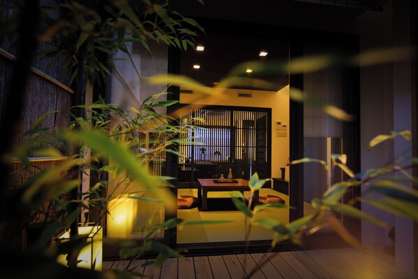 A traditional Japanese room with tatami flooring, a low table, and a sliding door.