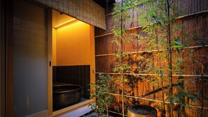 A traditional Japanese room with tatami flooring, a bamboo wall, and a large stone basin. - Kyo No Yado Gekkoan (Kyoto)