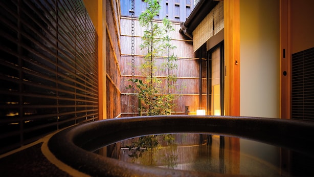 A traditional Japanese-style interior with a stone water feature, wooden sliding doors, and a bamboo plant. - Kyo No Yado Gekkoan (Kyoto)