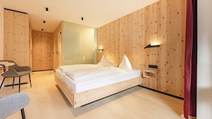 A modern bedroom with a wooden bed, a desk, and a chair. - Gasthof Gra Benhof (Vienna)