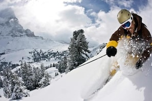 A person skiing down a snowy slope with a mountain in the background. - Hotel Lemon (Coudes)