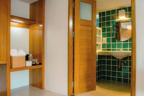 A wooden door leading to a bathroom with a green tiled wall and a white sink. - Alley & Pier (Bangkok)