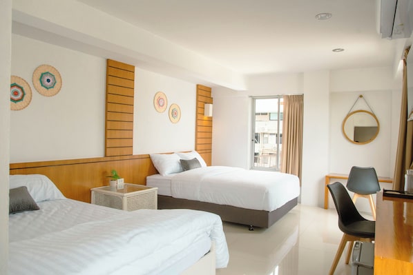 A hotel room with two beds, a desk, a chair, a mirror, and a view of the outside. - Alley & Pier (Bangkok)