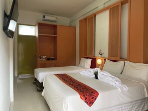 Habitación de hotel con una cama grande, un armario, un espejo y un televisor.