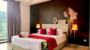 Une chambre d’hôtel comprenant un lit, deux lampes de chevet, une table de chevet, un miroir et un vase contenant des plantes séchées.