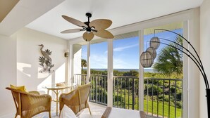 A balcony with wicker furniture, a ceiling fan, and a view of the ocean. - CP 134 Ocean View Condo - Vacation Rental in Ocean Village (Fort Pierce)