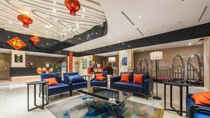 A modern hotel lobby with blue sofas, a glass coffee table, and red lanterns. - Ion Delemon Premier Suites Genting Highlands (Genting Highlands)