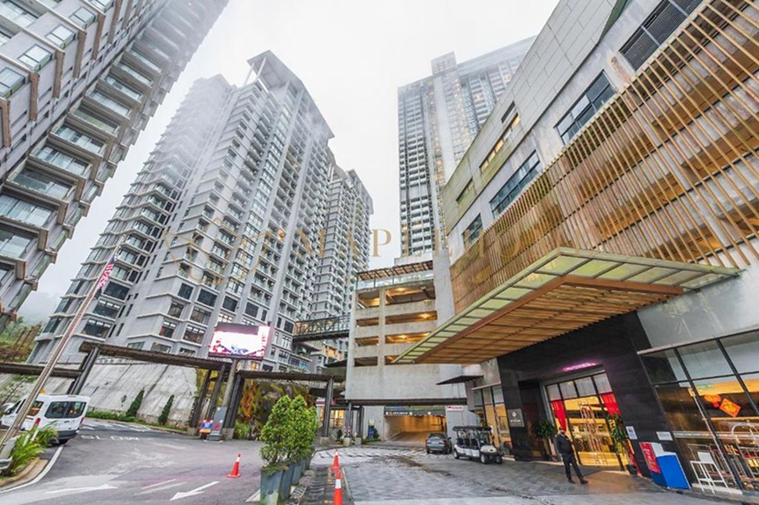 A modern urban hotel with high-rise buildings, a covered parking area, and a visible entrance.