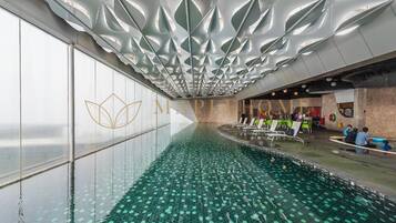 An indoor swimming pool with a unique ceiling design and a logo on the wall.