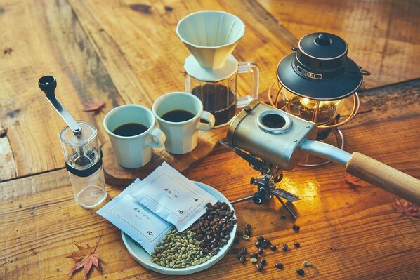 A coffee-making setup with a grinder, cups, a scale, and a calendar. - Loof Tiny House Camp (Fuefuki)
