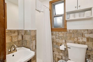 A bathroom with a sink, toilet, and a window. - Silvertip Pines #2335 (Big Bear Lake)