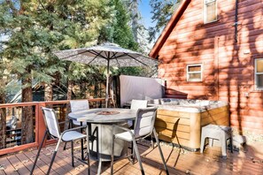 An outdoor patio with a round table, chairs, a fire pit, and a large umbrella. - Silvertip Pines #2335 (Big Bear Lake)