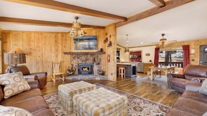 A spacious living area with a fireplace, leather sofas, and a dining table.