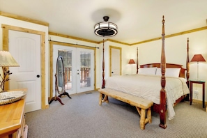 A bedroom with a four-poster bed, a wooden bench, a desk with a lamp, and a ceiling fan. - Happy Bear #2053 (Big Bear Lake)