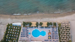 An aerial view of a beachside resort with a swimming pool, sun loungers, umbrellas, and a beach area. - Alykanas Beach Grand Hotel by Zante Plaza (Zakynthos)