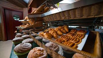 A bakery display with various baked goods like muffins, croissants, and pastries.