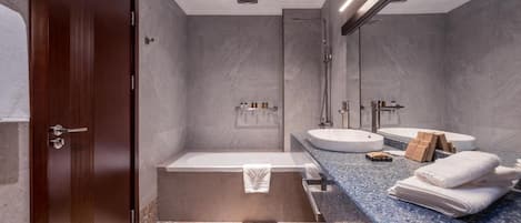 A modern bathroom with a wooden door, a bathtub, a sink, and a large mirror.