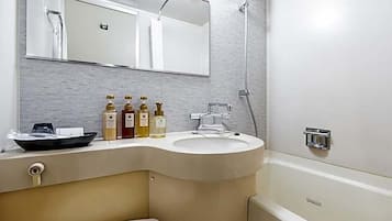 Een badkamer met een wastafel met gebogen rand, een spiegel erboven en een douchehoek.
