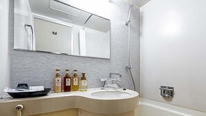 A bathroom with a curved sink, a mirror above it, and a shower area. - Sun Hotel Fukuyama (Fukuyama)