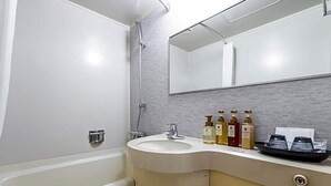 A bathroom with a white sink, a mirror, and toiletries on the counter. - Sun Hotel Fukuyama (Fukuyama)