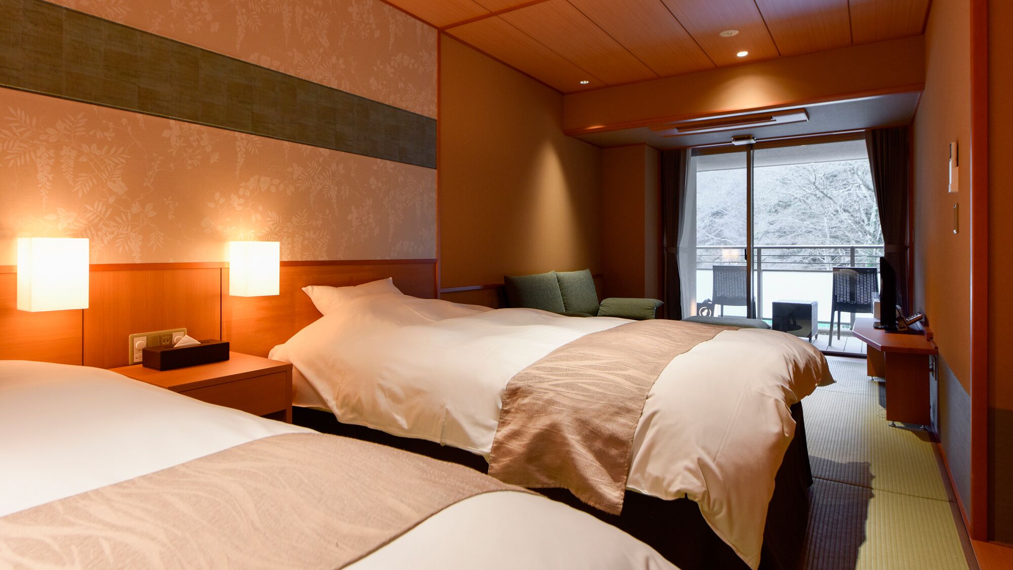 A hotel room with two beds, a large window, and a balcony.