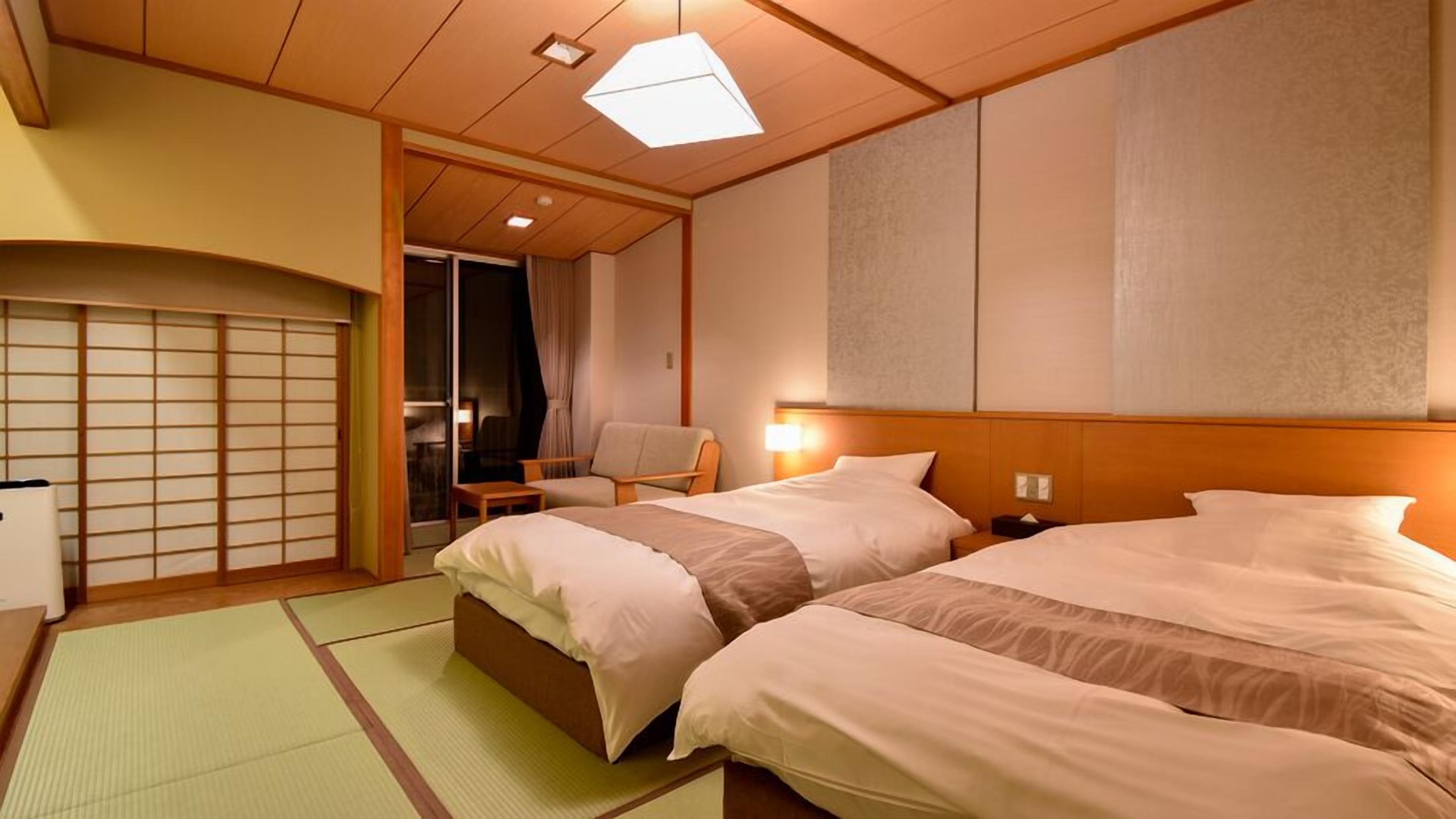 A hotel room with two beds, a traditional sliding door, a chair, and a small table.