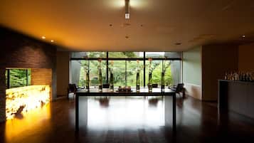Un interior moderno con una mesa larga, ventanas amplias y una chimenea.