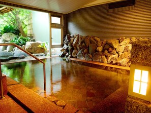 A stone wall with a water feature in a lobby area. - Ito Onsen Yukitei (Ito)