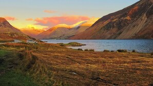 A mountainous landscape with a lake, a road, and a car.