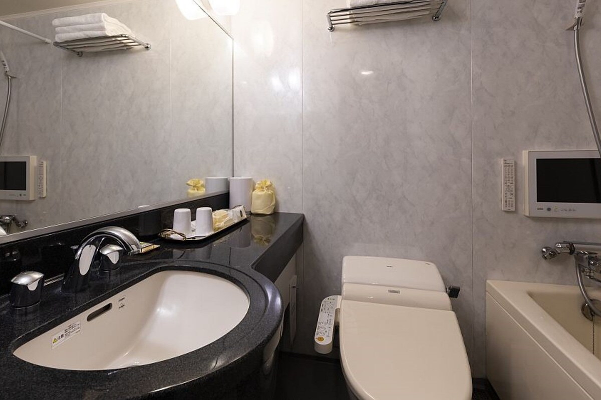 A modern bathroom with a large sink, a toilet, a bathtub, and a shower.