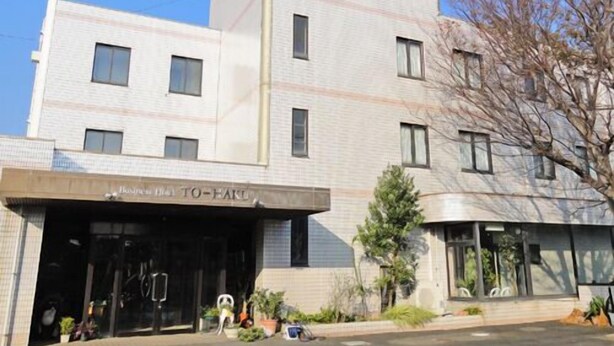 A multi-story hotel with a prominent 'TO-HANA' sign on the top. - Hotel Sunshine Tohaku (Kotoura)