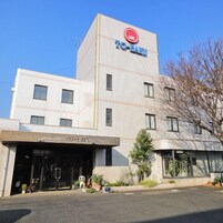 Um hotel com vários andares e um letreiro chamativo 'TO-HANA' no topo.