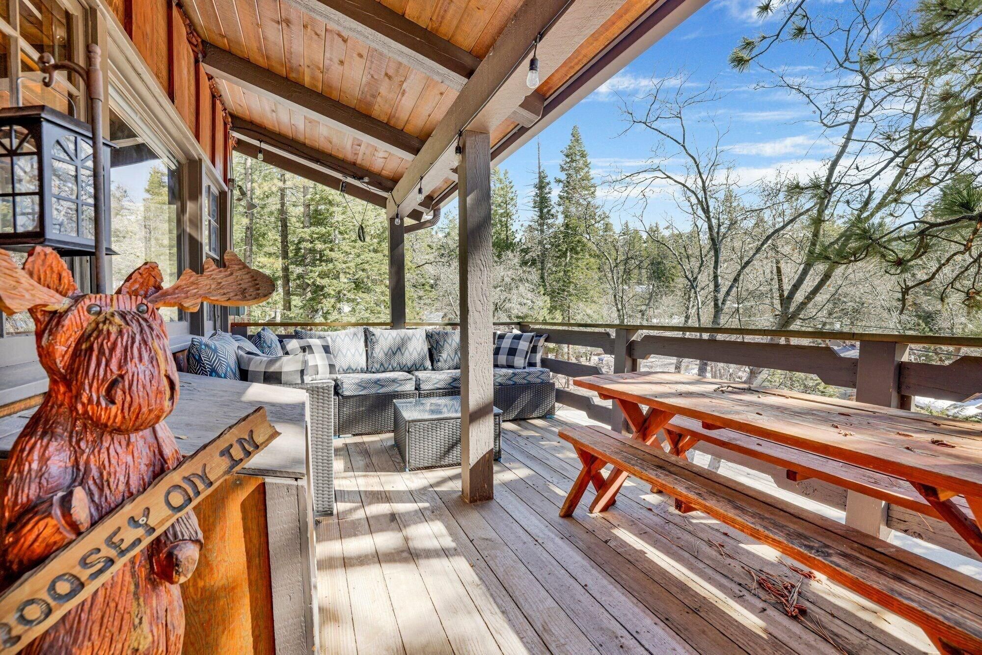 A wooden deck with outdoor seating and a wooden sculpture.
