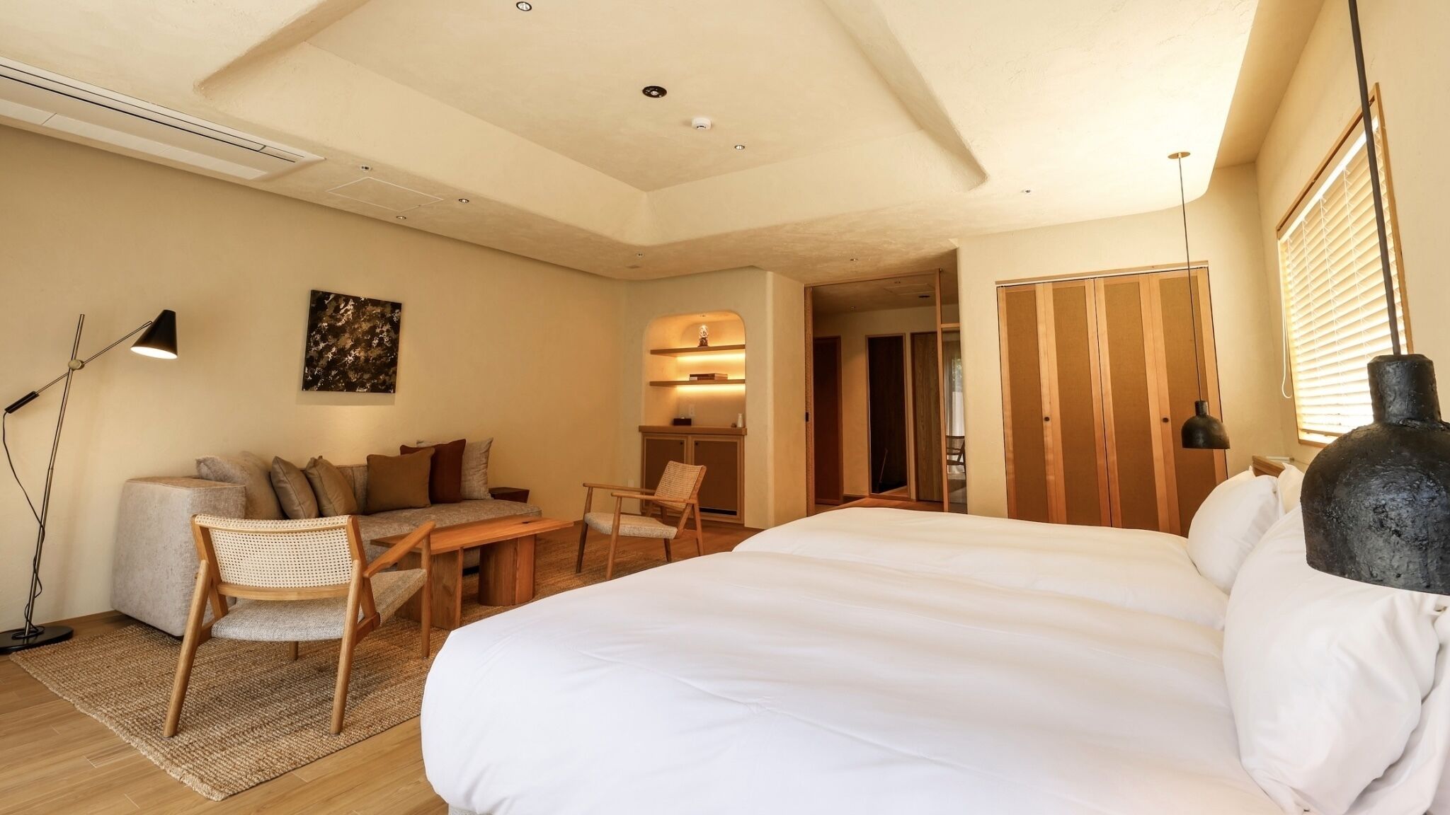 A bedroom with a bed, a sofa, a desk, and a chair.