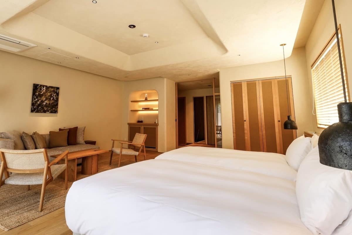 Une chambre à coucher avec un lit, un canapé, un bureau et une chaise.