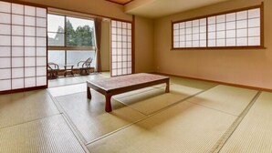 A traditional Japanese room with tatami flooring, a low wooden table, sliding shoji doors, and a view through a large window. - Susono Tansan Karushiumu Onyoku Inchinose (Susono)