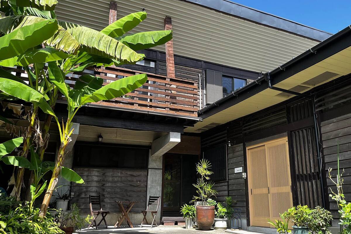 A modern building with a wooden balcony, potted plants, and a door labeled 'Spa Room'.