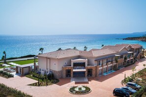 Un resort con piscina, un patio techado y vistas al mar.