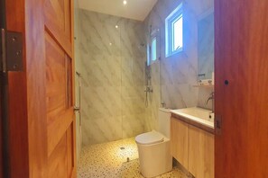Un baño con ducha, inodoro y lavamanos.
