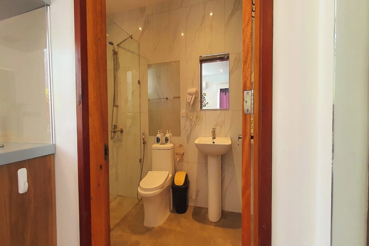 Une salle de bain avec des toilettes, un lavabo et une douche.