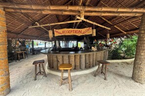 Un espace d’accueil doté d’un plafond en bambou, d’une enseigne indiquant « Mabuhay, bienvenue » et d’un comptoir de bar avec des tabourets.