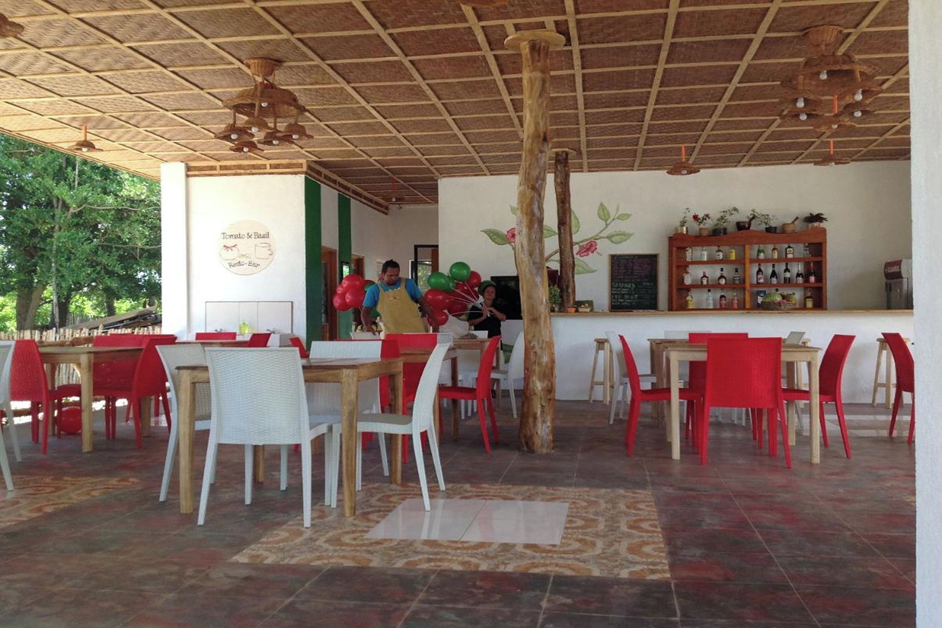 A restaurant with wooden tables and chairs, a bar area with bottles, and a sign indicating a Brazilian theme.